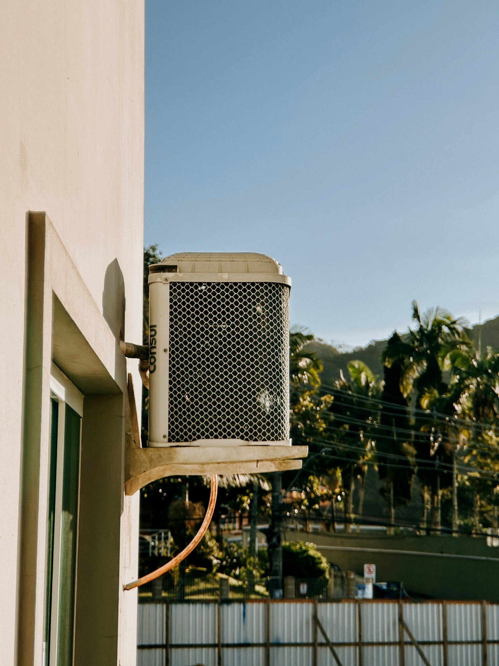 Residential outdoor heat pump unit mounted beside a home
